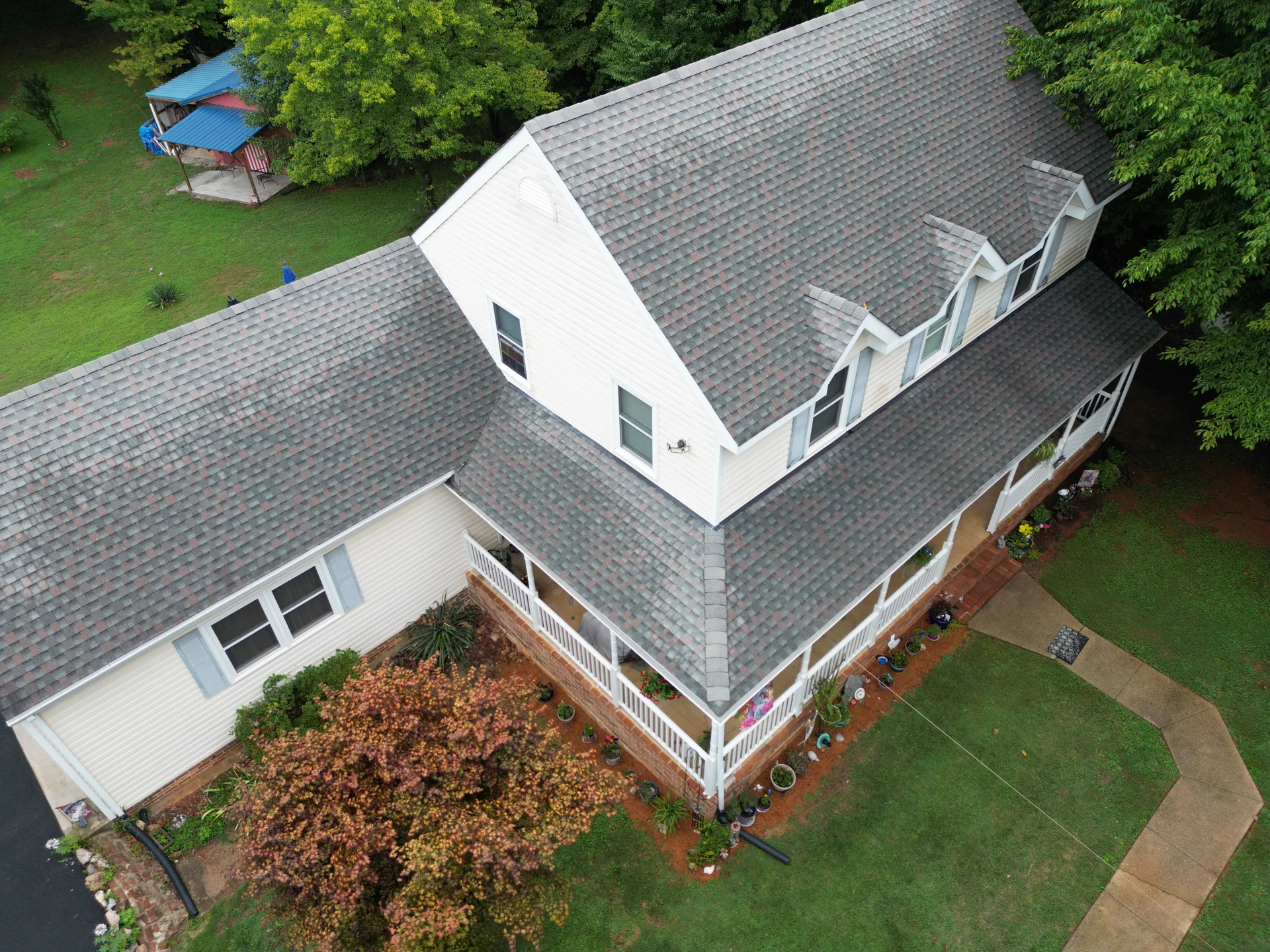 Aerial view of a Cape Cod-style home in Amherst County, Virginia, with dormer windows and a wraparound porch